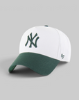 A white and dark green baseball cap featuring the New York Yankees interlocking logo on the front and a '47' brand logo on the side, set against a solid gray background.