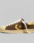 Side view of a brown converse shoe, cream sole and tan star