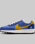 A Nike ACG LDV sneaker in blue and yellow, featuring a blue mesh upper, a yellow Swoosh, a white midsole, and a black outsole, shown against a solid gray background.