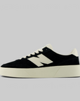 A low-top sneaker in black suede and off-white leather, featuring a thick off-white platform sole and a large 'N' logo on the side, photographed against a solid light gray background.