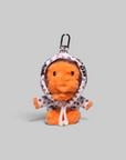 An orange plush monkey keychain wearing a white hooded raincoat with small red and black polka dots, attached to a black metal clasp, shown on a solid gray background.