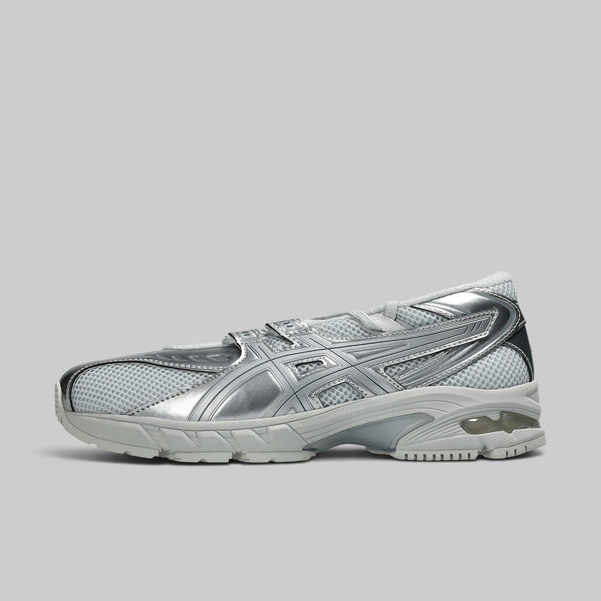 A metallic silver athletic sneaker with mesh panels and a chunky sole, shown in profile against a solid gray background.