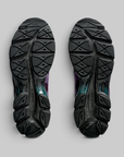 The outsoles of a pair of running shoes, shown from a top-down view against a neutral gray background. The outsoles are solid black with a textured, geometric tread pattern.