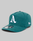 A teal green baseball cap with a white embroidered letter 'A' on the front and a white New Era logo on the side, shown on a neutral gray background.