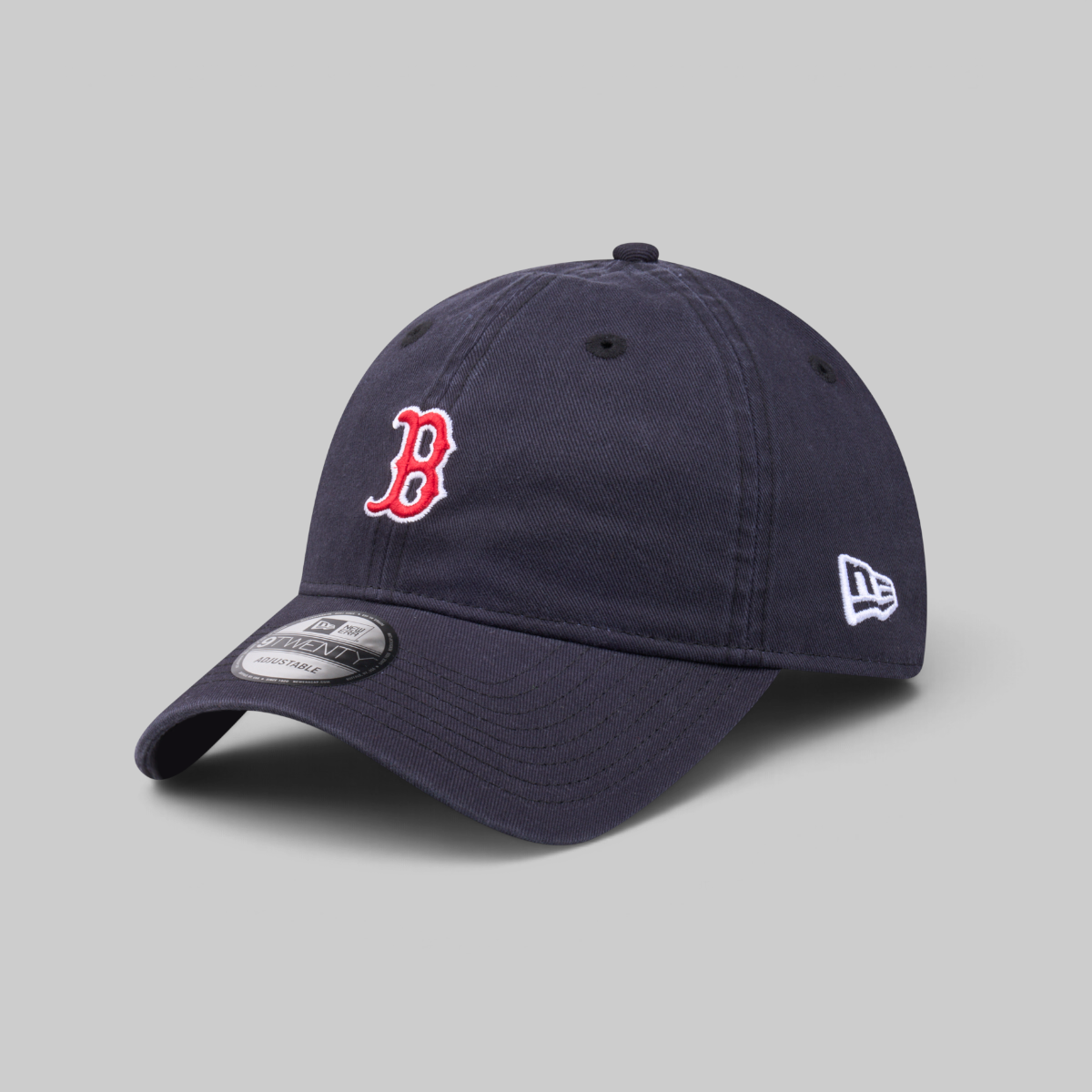A navy blue baseball cap with a red embroidered Boston 'B' logo on the front and a white New Era logo on the side, shown on a neutral gray background.