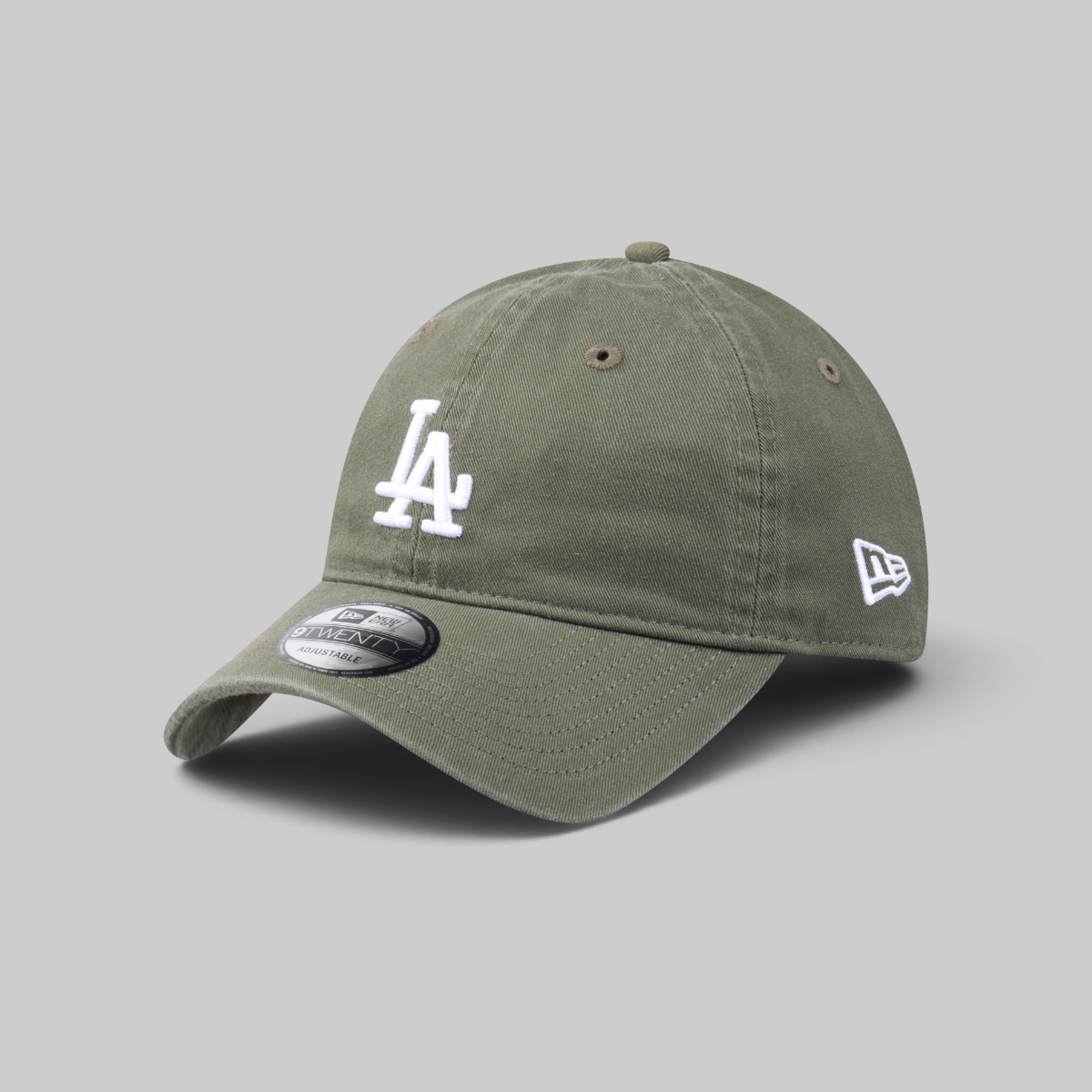 An olive green baseball cap featuring a white embroidered 'LA' logo on the front and a white New Era logo on the side, set against a solid gray background.