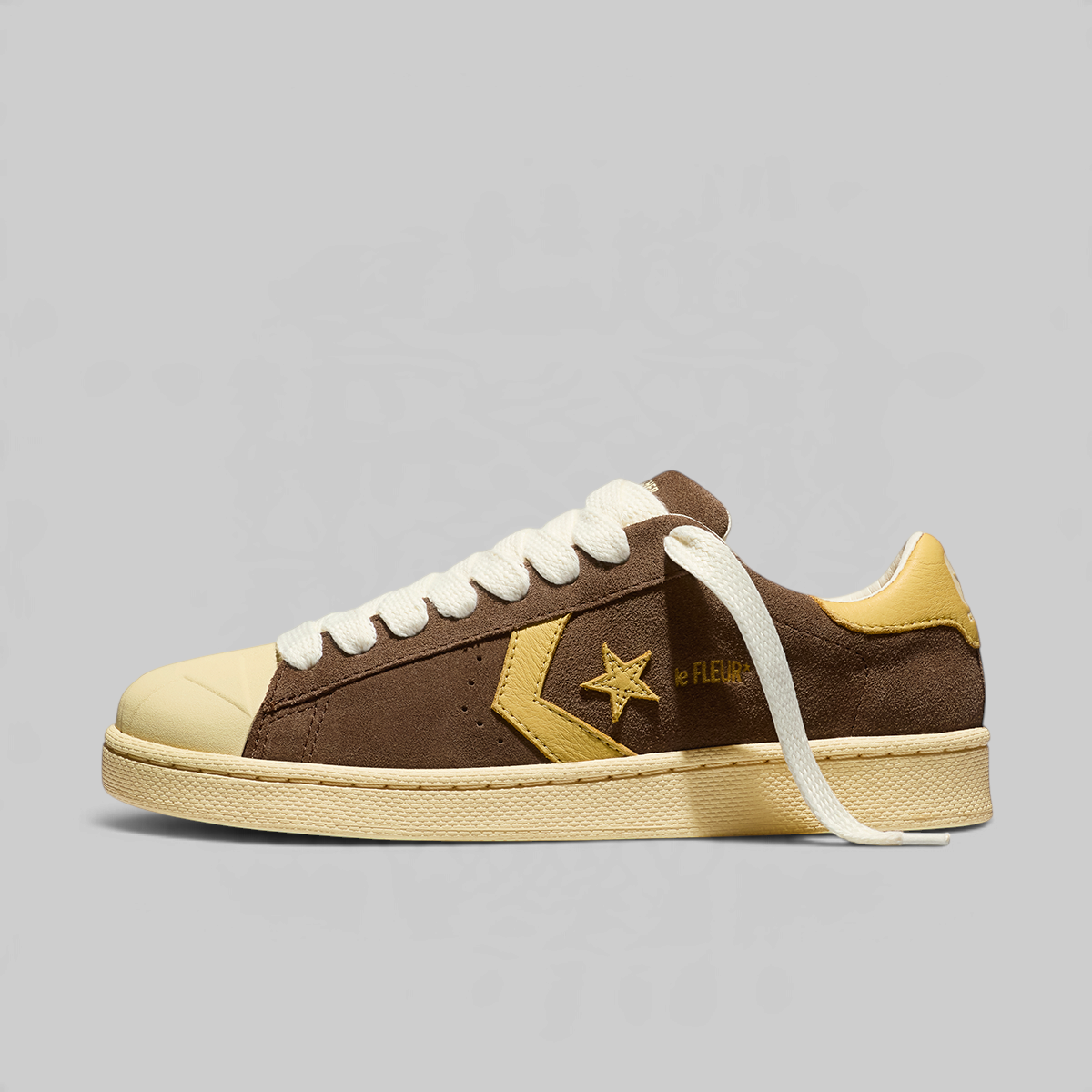 Side view of a brown converse shoe, cream sole and tan star