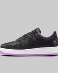 Black and white Nike Air Force 1 sneaker on a light gray background
