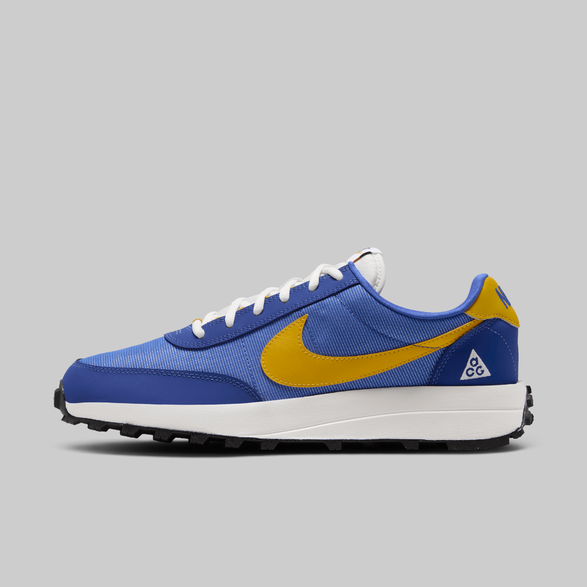 A Nike ACG LDV sneaker in blue and yellow, featuring a blue mesh upper, a yellow Swoosh, a white midsole, and a black outsole, shown against a solid gray background.