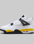 A white Air Jordan 4 sneaker with a black and yellow speckled midsole, navy blue lace wraps, and a black ankle strap, shown in a side profile on a solid gray background.