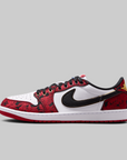 A Nike Air Jordan 1 Low sneaker in red, white, and black, featuring a red and black patterned leather upper, a black Swoosh, and a white midsole, shown against a solid gray background.