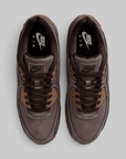 A pair of Nike Air Max 90 sneakers in a monochromatic dark brown colorway.