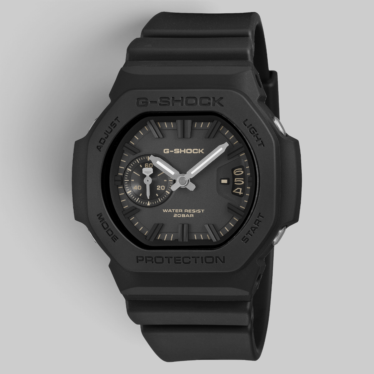 A G-Shock analog watch with a matte black resin case and strap, featuring a black dial with silver hands and small yellow accents.