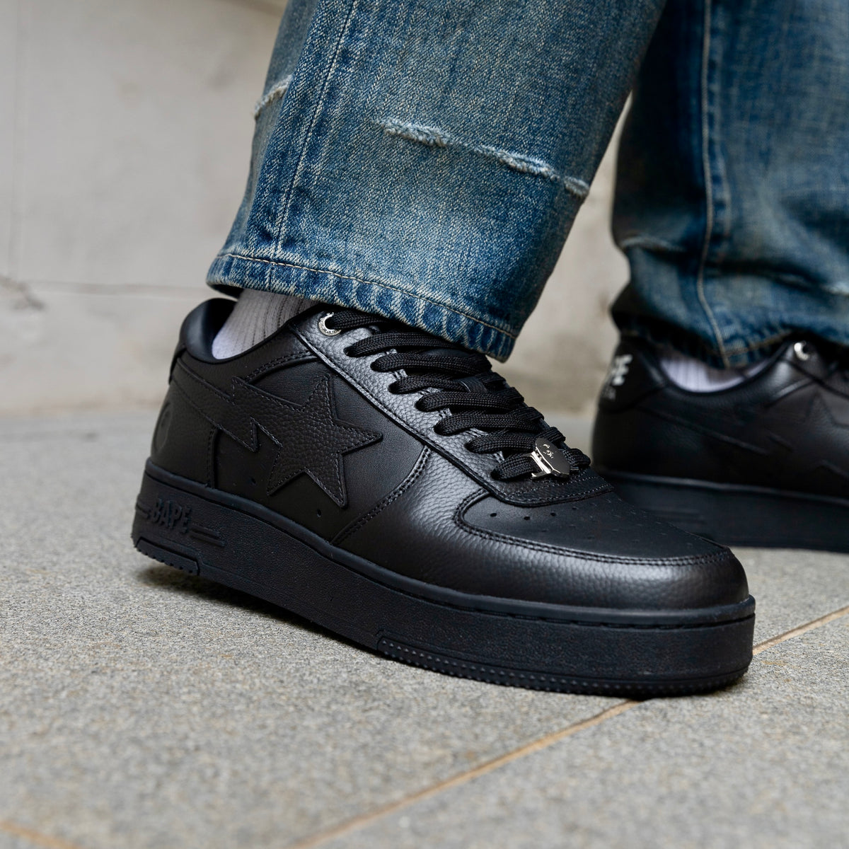 A  pair of low-top black leather Bape sneakers 