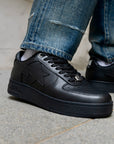 A  pair of low-top black leather Bape sneakers 