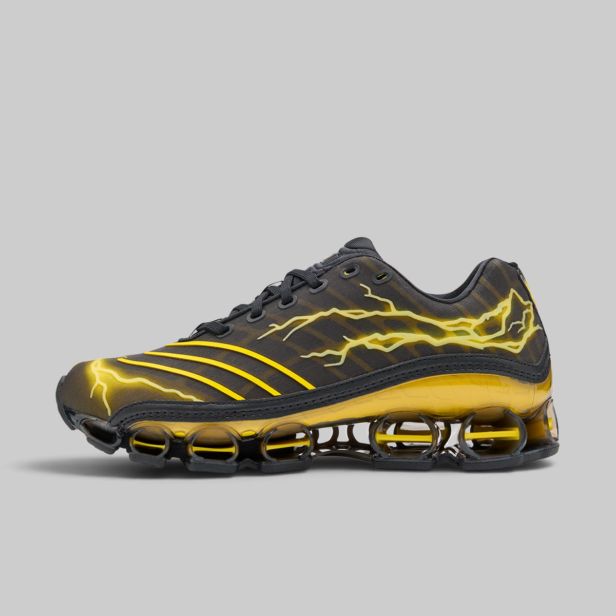 A black and yellow athletic sneaker with a textured upper, yellow lightning bolt graphics, and a distinctive yellow and black cushioned sole, shown against a solid gray background.