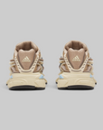 A pair of Adidas Pharrell Williams Adistar Jellyfish - "Crystal Sand" sneakers shown from the back, featuring a chunky beige and tan design with a textured leather heel tab and light blue geometric accents on the midsole.