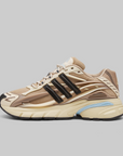Adidas Pharrell Williams Adistar Jellyfish - "Crystal Sand" sneaker in beige and brown with black three-stripes and a light blue accent on the midsole, shown in a side profile on a solid gray background.