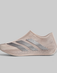 A low-top athletic shoe in a light beige mesh knit material with three metallic silver stripes, shown from a side profile on a solid gray background.