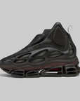 A single black high-top sneaker with a sculpted, bubble-like upper and a thick, sculptural sole featuring visible air-like chambers, photographed on a plain light gray studio background.