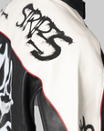 Close-up of a black and white leather jacket with red piping, featuring a large black graffiti-style 'SRT 5' graphic on the shoulder and a white skull graphic on the side.
