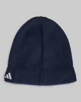 A navy blue ribbed knit beanie hat with a white Adidas logo on the folded cuff, shown against a solid light gray background.