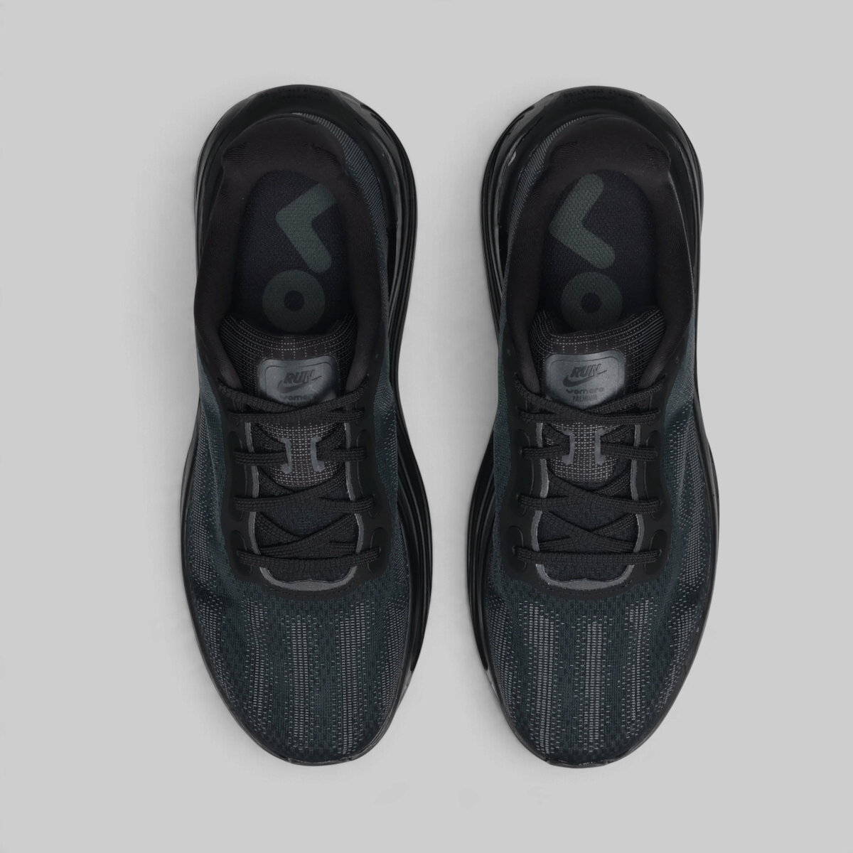 A pair of Nike Air Force 1 Ultra sneakers in black and dark gray, shown from a top-down view on a light gray background.