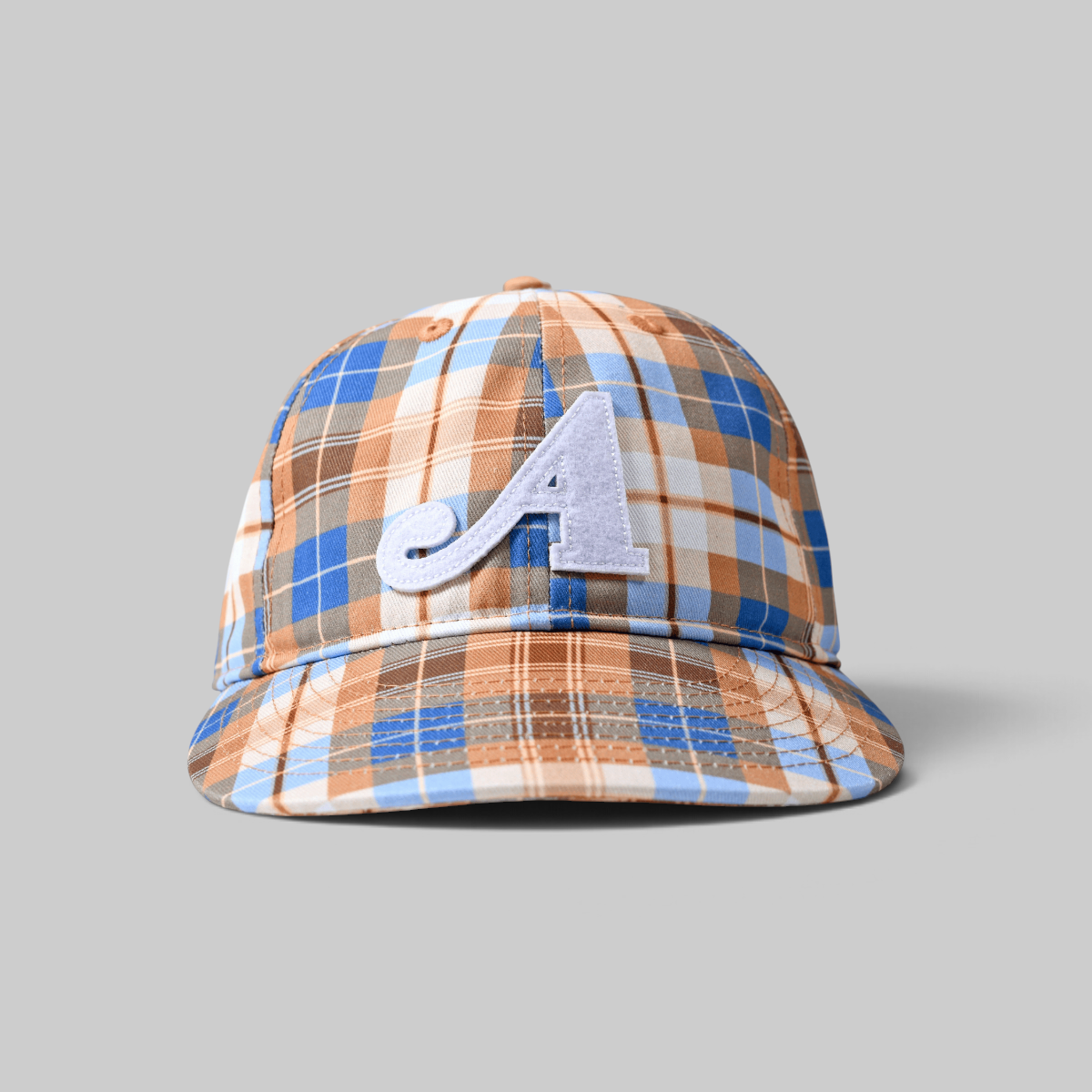 A structured baseball cap featuring a blue, brown, and white plaid pattern with a light blue embroidered letter 'A' on the front, set against a solid gray background.