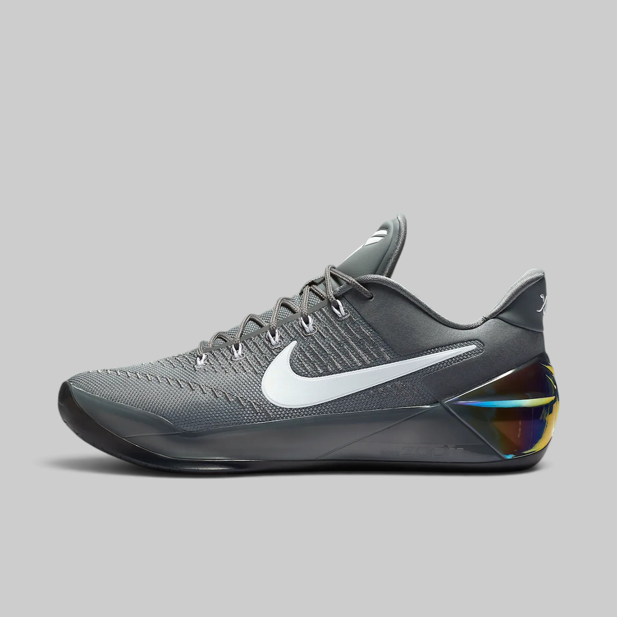 A Nike basketball shoe in dark gray with a white Swoosh logo and a translucent heel counter showing a multicolor iridescent insert, set against a solid gray background.