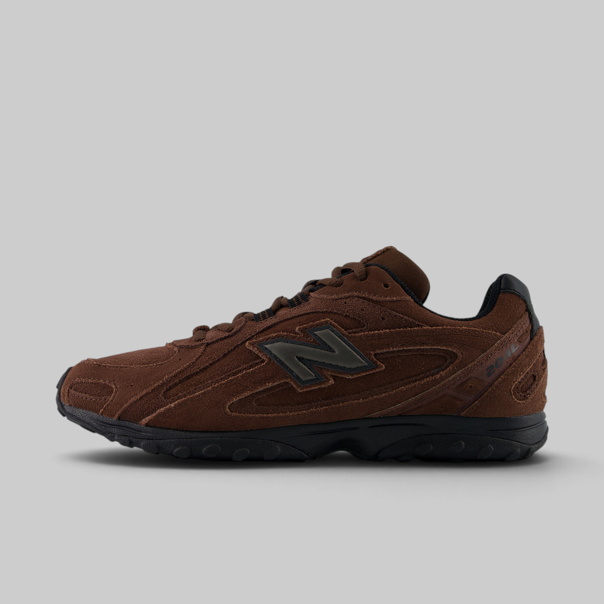 A brown New Balance sneaker with a dark gray 'N' logo and black sole, shown in a side profile on a light gray background.